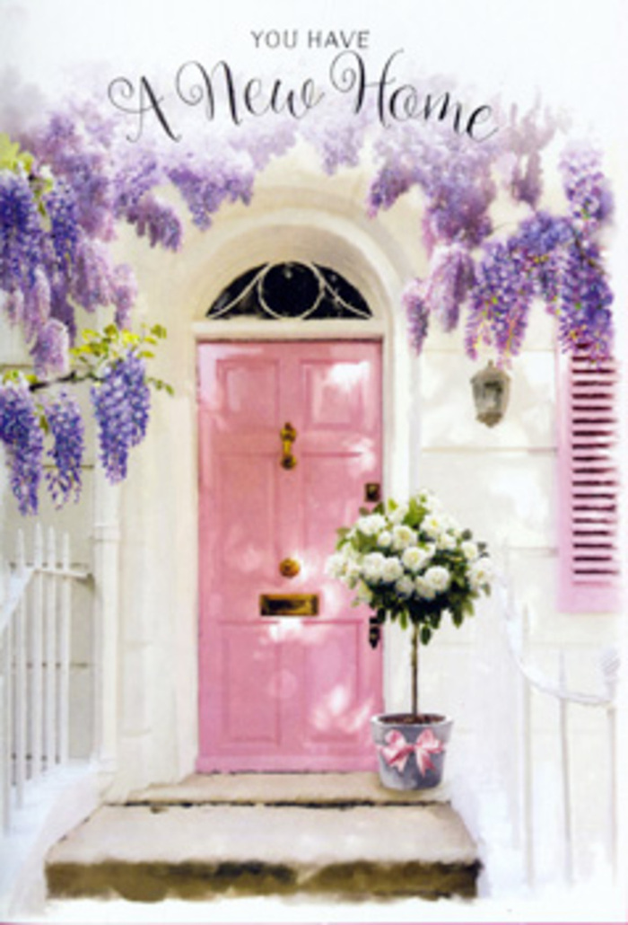 A romantic front door scene unfolds in what could easily be a peaceful street in Longford, capturing the emotion of crossing a new threshold. The door itself is painted a soft, comforting pink, its panels subtly highlighted by the afternoon light that slides in from one side. Beside it, a pastel shutter, brushed in the same tender hue, leans open on a whitewashed wall, making the entry feel bright and airy. Above, wisteria in full bloom cascades in tumbling trails of lavender and lilac, each cluster of blossoms seeming to drip from sturdy vines that twist just out of sight. Their presence suggests a heady, springlike perfume, drifting down over the step. At that step, in the very centre of the doorway, sits a grey metal bucket filled with an opulent gathering of white roses. Each rose is open and layered, the petals creamy and slightly ruffled, interlaced with soft greenery that gives the bouquet shape and movement. A satin ribbon in blush pink is tied around the bucket, its neat bow and loose ends introducing a gentle, celebratory flourish. The light is warm but not harsh, casting subtle shadows that add depth to the stone step and the curves of each bloom. The scene feels like a housewarming moment in still life, the sort of floral welcome someone in Longford might arrange to greet loved ones after a big move. It speaks of fresh starts, cosy evenings, and that first delighted glance back at your own front door, dressed in flowers that make the house feel truly like home.